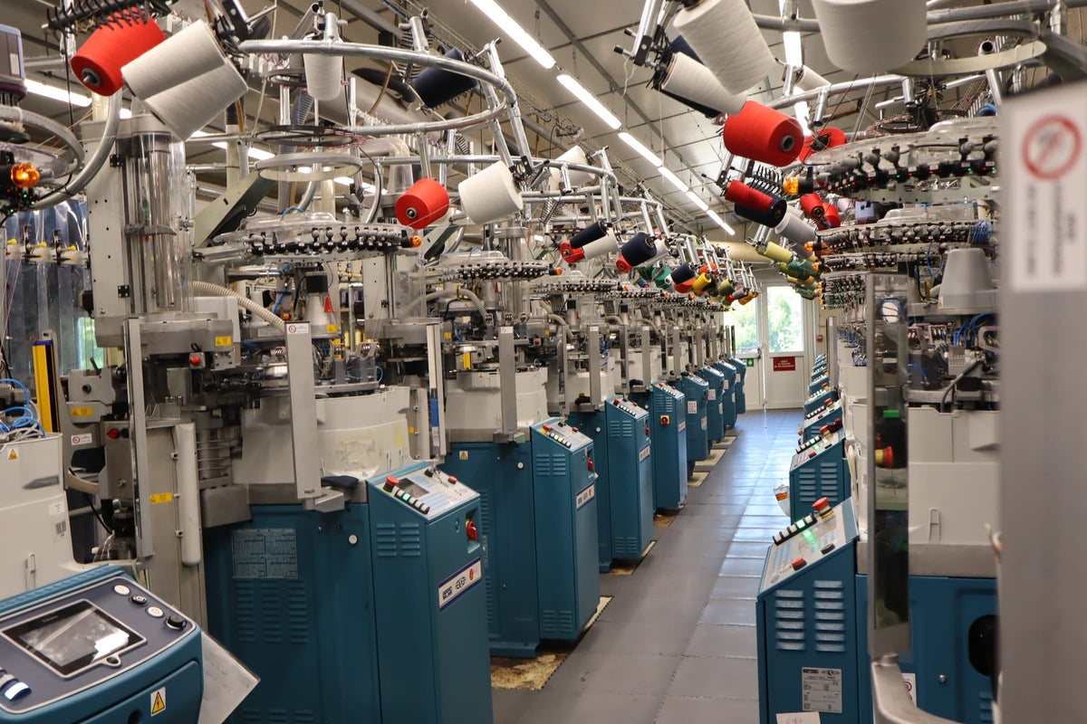Atelier de tricotage de chaussettes avec ses machines circulaires et ses bobines de fil